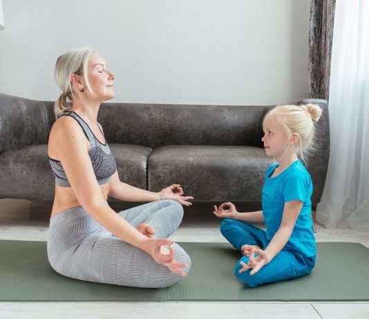 The half lotus pose (Ardha Padmasana) is an effective hip opener pose. (Photo by Mikhail Nilov via pexels)