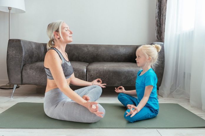 The half lotus pose (Ardha Padmasana) is an effective hip opener pose. (Photo by Mikhail Nilov via pexels)