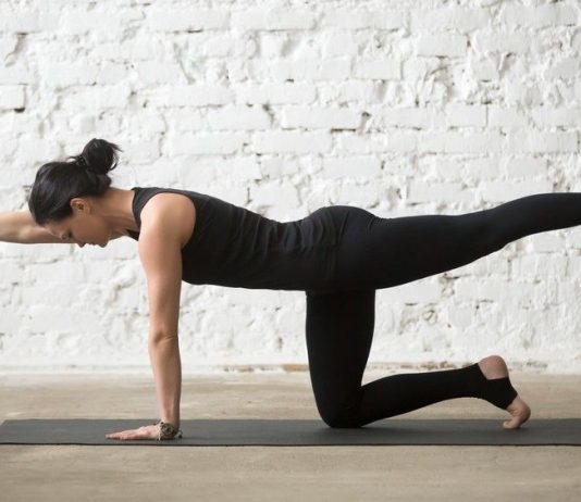 a photo of a woman doing a birddog 