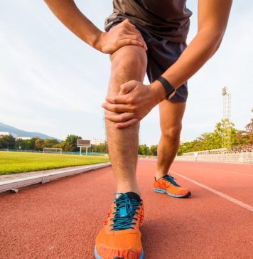 a photo of a runner holding his injured knee
