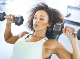 Los mejores ejercicios para los músculos del pecho. Best exercise for chest: Image shows young woman lifting dumbbells