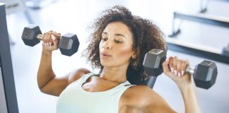 Best exercise for chest: Image shows young woman lifting dumbbells