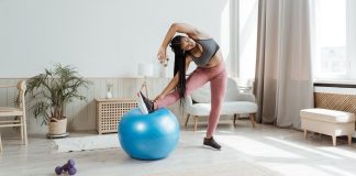 woman using blue exercise ball to stretch her legs