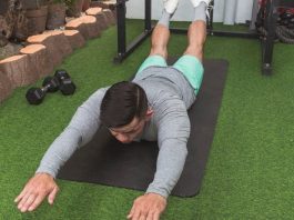 a photo of a man doing the superman exercise