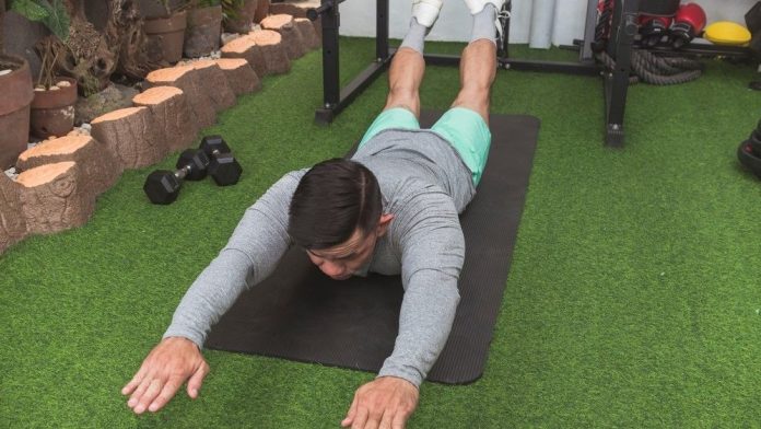 a photo of a man doing the superman exercise