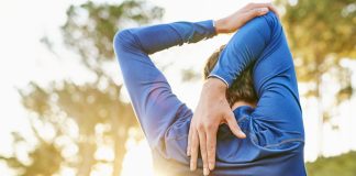 Why do muscles get sore after exercise? Image shows man stretching