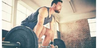 Man demonstrating how to deadlift using barbell