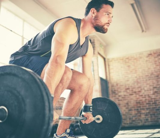 Man demonstrating how to deadlift using barbell
