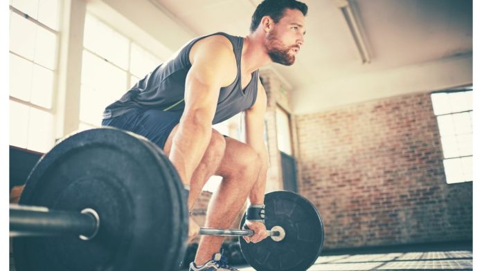 Man demonstrating how to deadlift using barbell