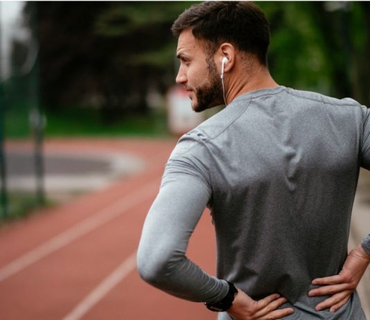 ¿Ciática? Estos son los ejercicios a evitar, dice un experto Sciatica: Man holding his lower back in pain during workout on a running track